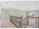 Upstairs hallway with wrought iron railing, carpet, and view of the front door below at 541 Lombard St, Marietta, GA 30064