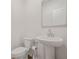 Neat half bathroom featuring a pedestal sink, a round mirror, and a toilet at 802 Milo Bay St, Loganville, GA 30052