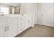 Bright bathroom featuring double vanity with white cabinets and a glass shower at 802 Milo Bay St, Loganville, GA 30052