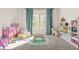 Playroom featuring carpeted floors, playful decor, and natural light streaming through two windows with teal curtains at 802 Milo Bay St, Loganville, GA 30052