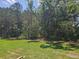 Lush green backyard with mature trees and a serene view at 2674 Ne Almand Ne Ln, Conyers, GA 30013