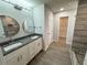 A well-lit bathroom featuring double sinks with modern fixtures, a large mirror, and tiled walls at 1351 E Atlanta E Rd, Stockbridge, GA 30281