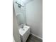 Modern half-bath features a sleek vanity with a round mirror and stylish lighting fixture at 1351 E Atlanta E Rd, Stockbridge, GA 30281
