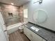 A modern bathroom featuring granite countertop, white vanity, and a tiled shower/tub at 1351 E Atlanta E Rd, Stockbridge, GA 30281