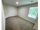 A bright bedroom featuring neutral walls and soft, gray carpet with natural light from a large window at 1351 E Atlanta E Rd, Stockbridge, GA 30281