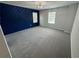 A spacious bedroom with a striking blue accent wall and large windows at 1351 E Atlanta E Rd, Stockbridge, GA 30281