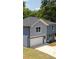 A two-story home features mixed siding, an attached garage, and a beautifully landscaped entrance at 1351 E Atlanta E Rd, Stockbridge, GA 30281