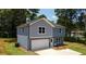 This two-story home features mixed siding, an attached garage, and a front lawn with mature trees surrounding the property at 1351 E Atlanta E Rd, Stockbridge, GA 30281