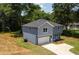Two-story home featuring gray-blue siding, an attached garage, and mature trees enhancing the backyard at 1351 E Atlanta E Rd, Stockbridge, GA 30281