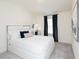 Bedroom featuring a white bed, nightstand, decorative pillows, large window and luxurious drapes at 2680 Ne Almand Lane Ne, Conyers, GA 30013