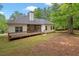 Spacious backyard with mature trees, featuring a screened porch and wooden deck at 5071 Woodmont Dr, Villa Rica, GA 30180