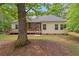 Backyard view featuring a deck, screened porch, and lush greenery at 5071 Woodmont Dr, Villa Rica, GA 30180