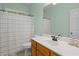 Fresh bathroom with mint green walls, white sink and toilet, and a shower-tub combo at 5071 Woodmont Dr, Villa Rica, GA 30180