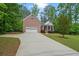 Lovely brick home with an attached garage, front porch, and long driveway at 5071 Woodmont Dr, Villa Rica, GA 30180
