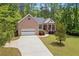 Charming brick home featuring a columned front porch and a well-manicured lawn at 5071 Woodmont Dr, Villa Rica, GA 30180