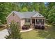 Charming brick home featuring a columned front porch and a well-manicured lawn at 5071 Woodmont Dr, Villa Rica, GA 30180