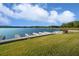 Scenic lake view with wooden docks extending into the water, showcasing the lush green lawn and clear sky at 5071 Woodmont Dr, Villa Rica, GA 30180