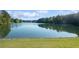 Tranquil lake view with grassy shoreline, showcasing the peaceful natural surroundings at 5071 Woodmont Dr, Villa Rica, GA 30180