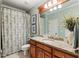 Clean and updated bathroom with a vanity, granite countertop, and a shower/tub combination with a floral curtain at 13230 Addison Rd, Roswell, GA 30075
