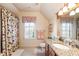 Bright bathroom featuring granite countertops, floral shower curtain and a window with white shutters at 13230 Addison Rd, Roswell, GA 30075