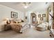 Comfortable bedroom features floral bedding, a ceiling fan, and a cozy armchair with ottoman at 13230 Addison Rd, Roswell, GA 30075