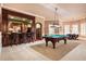 Spacious game room with a pool table, bar area, and elegant lighting fixtures at 13230 Addison Rd, Roswell, GA 30075
