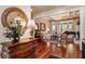 Elegant living room with hardwood floors, coffered ceilings, and a large round mirror in the foyer at 13230 Addison Rd, Roswell, GA 30075