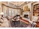 Cozy living room featuring a fireplace, built-in bookshelves and a decorative rug on hardwood floors at 13230 Addison Rd, Roswell, GA 30075