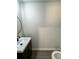 This bathroom features a dark vanity with a white sink and a black faucet, plus a round black framed mirror at 1341 E Atlanta E Rd, Stockbridge, GA 30281