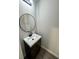 Modern half bathroom features a sleek round mirror and a white quartz countertop at 1341 E Atlanta E Rd, Stockbridge, GA 30281