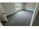 An empty carpeted bedroom with a window for natural light and white trim at 1341 E Atlanta E Rd, Stockbridge, GA 30281