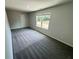 A well-lit bedroom featuring neutral walls, plush carpeting, and a window offering a view of the outdoors at 1341 E Atlanta E Rd, Stockbridge, GA 30281