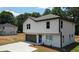 Two-story home featuring a paved driveway leading to an attached garage, complemented by a manicured lawn at 1341 E Atlanta E Rd, Stockbridge, GA 30281