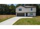 Charming two-story home with a well-manicured lawn and a paved driveway leading to an attached garage at 1341 E Atlanta E Rd, Stockbridge, GA 30281