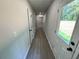 Hallway with luxury vinyl plank flooring leading to a door to the backyard with 3 doors on the left at 1341 E Atlanta E Rd, Stockbridge, GA 30281