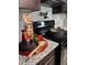 The kitchen has a black range with a pot, colorful peppers, pasta and a wooden spoon on the granite countertop at 1341 E Atlanta E Rd, Stockbridge, GA 30281