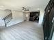 Spacious living area with gray flooring, a staircase, and a kitchen with dark cabinets and an island at 1341 E Atlanta E Rd, Stockbridge, GA 30281