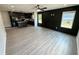 Open-concept living room and kitchen area with gray flooring, dark accent wall, and abundant natural light at 1341 E Atlanta E Rd, Stockbridge, GA 30281