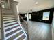 Bright living room with hardwood floors, dark accent wall, and staircase leading to the second floor at 1341 E Atlanta E Rd, Stockbridge, GA 30281