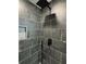 Modern gray tiled shower with shower head and mosaic niche at 1341 E Atlanta E Rd, Stockbridge, GA 30281