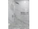 Close up of a marble tiled walk-in shower with a modern shower head and niche at 1346 Wichita Sw Dr, Atlanta, GA 30311