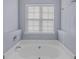 Bright bathroom featuring a soaking tub beneath a window, offering a relaxing space at 2825 Windsor Forrest Ct, Atlanta, GA 30349