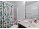 Bright bathroom with a patterned shower curtain, white sink, and a large mirror at 5885 San Gabriel Ln, Atlanta, GA 30349