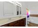 Bathroom with a double sink vanity, large mirrors, a bathtub, and a separate toilet at 5885 San Gabriel Ln, Atlanta, GA 30349