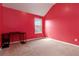 Bedroom with red walls, carpet flooring, and window providing natural light at 5885 San Gabriel Ln, Atlanta, GA 30349