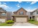 Inviting two-story home featuring a brick and neutral toned facade, a two-car garage, and well-manicured landscaping at 5885 San Gabriel Ln, Atlanta, GA 30349