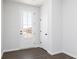 Entryway with dark wood-look floors and white trim is illuminated by natural light from the glass pane door at 616 Devon Aly, Acworth, GA 30102