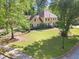 Inviting two-story home with a well-manicured lawn and mature trees surrounding the property at 7389 Tidewater Trce, Stone Mountain, GA 30087