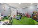 Bright playroom with artificial grass flooring and lots of games and toys at 7389 Tidewater Trce, Stone Mountain, GA 30087