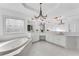 Bright bathroom features a soaking tub beneath a decorative window and double vanities with modern fixtures at 4065 Tritt Homestead Dr, Marietta, GA 30062